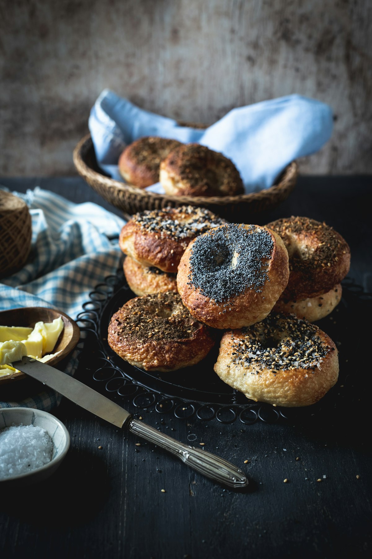 Assorted seeded bagels on a dark tray